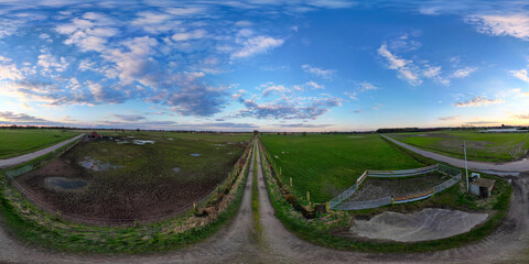 A 360-degree panorama revealing an endless farm road beneath a vast, cloud-strewn sky, embodying...