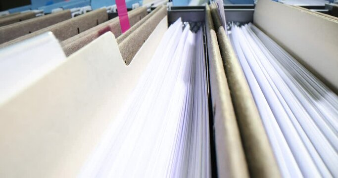Rows of business folders in a file cabinet with closeup