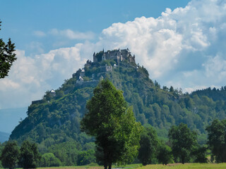 Panoramic view of medieval castle Burg Hochosterwitz build on hilltop in Sankt Georgen am Längsee, Sankt Veit an der Glan, Carinthia, Austria. Hill is surrounded by vast forest. Clouds building up