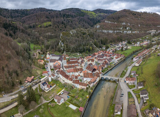 Aerial view of the small medieval town St-Ursanne on River Doubs under Jura Mountains. Saint-Ursanne was once rewarded as one of the most beautiful towns in Switzerland.