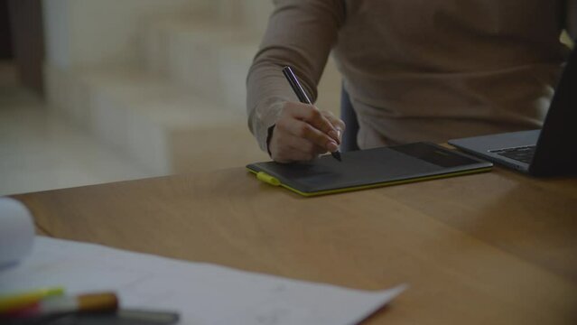 Acercamiento de la mano de un arquitecto o dise&ntilde;ador gr&aacute;fico trabajando en tableta gr&aacute;fica