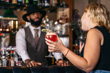 Stylish bartender offering a cocktail