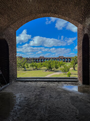 View through an open archway in Fort Jefferson on Dry Tortugas National Park with a the open courtyard a parade ground in the distance.