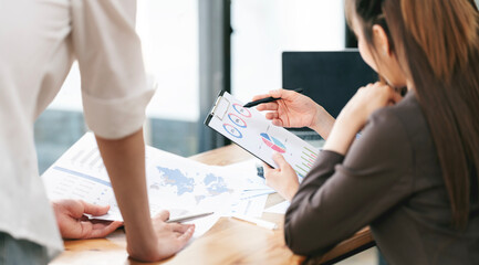 Group of business people working, discussing business strategy at office desk.