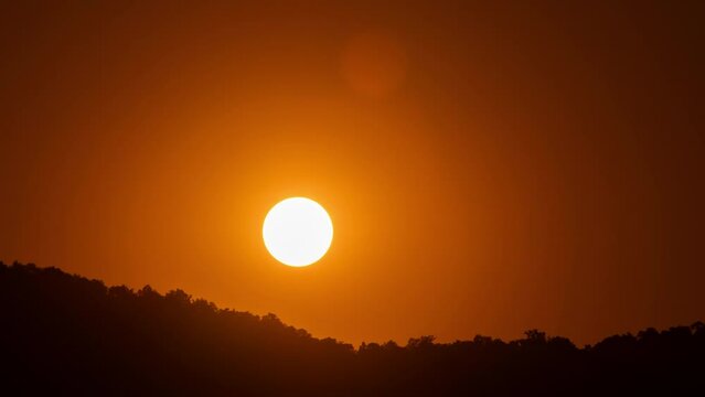 Timelapse of dramatic sunrise with orange sky in a sunny day.