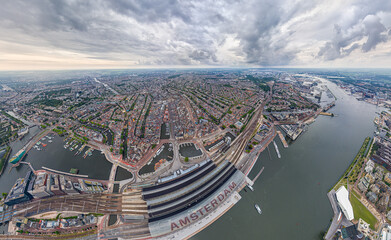 Amsterdam, Netherlands. Central Railway Station. Panorama of the city on a summer morning in cloudy weather. Aerial view