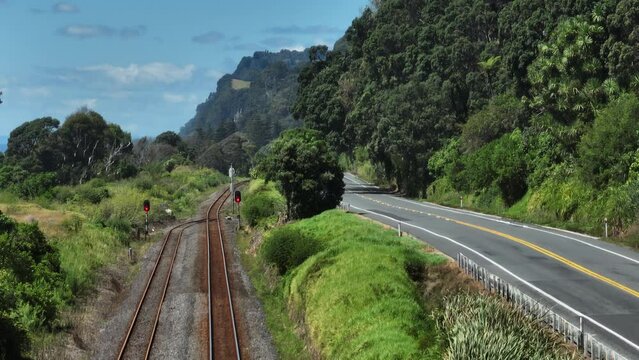 Aerial: Country road, traffic and pohutukawa grove near Pikowai, Bay of Plenty, New Zealand.