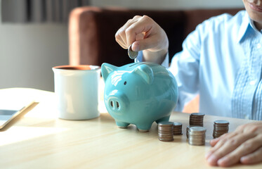 Young woman are putting coins in the piggy bank Saving money with coins Step into a business the...