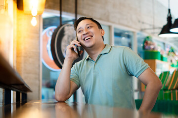 Modern Connectivity in Urban Cafe. Man using phone smiling in a Cafe