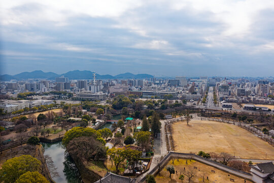 View from rooftop of famous Unesco Word Heritage site Himeji-jo castle over park and Japanese City of Himeji on a cloudy gray winter day. Photo taken February 1st, 2024, Himeji, Japan.