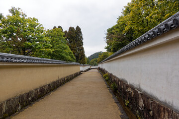 Diminishing perspective of pathway at famous Unesco Word Heritage site Himeji-jo castle on a cloudy gray winter day. Photo taken February 1st, 2024, Himeji, Japan.