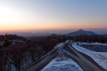 High angle view of empty car parking at Tottori Flower Park with sunset, scenic landscape and bay of water in the background on a sunny winter day. Photo taken February 13th, 2024, Tottori, Japan.