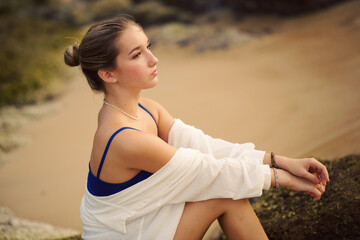 Young beautiful teenager girl with long hair european model posing on the sunset beach