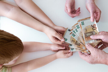 Causcian arms and hands are wanting 50 euro banknotes from old mans hand, flatlay image on white background. - obrazy, fototapety, plakaty
