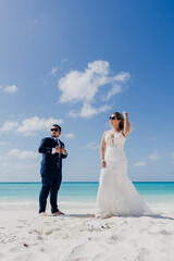 Fototapeta na wymiar newlyweds on the beach enjoying the Caribbean, in a trash the dress session