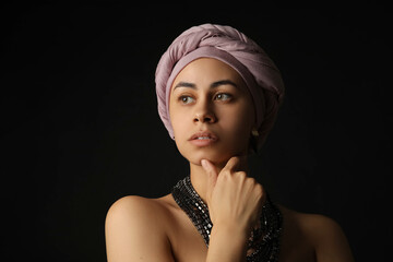 Fashionable young African-American woman on black background