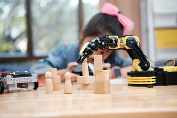 A young girl is playing with a remote control a robot