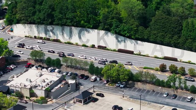 Lenox Road Traffic By The Buckhead Wall In Atlanta, Georgia. - zoom out shot