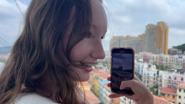  Cable car cabin takes selfie ride Girl laughs, eyes glow, takes pictures on mobile phone for social networks, joy, pleasure Tourist in Vietnam Phu Quoc Island Sunset Town Vietnam Sun World Hon Thom