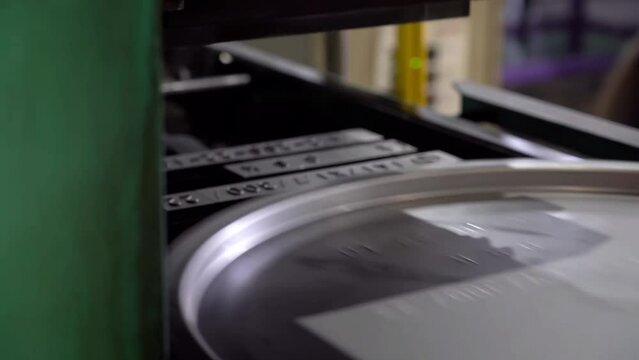 A metal stamping machine presses identification numbers into the drum lids.