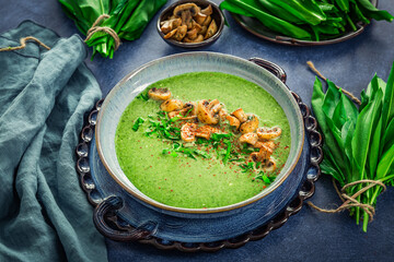 Creamy homemade bear leek soup or ramson soup with fried champignons