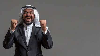 Overjoyed pleased Arabian businessman raising his fist, happy ecstatic