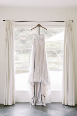 Wedding dress on hanger in bright room