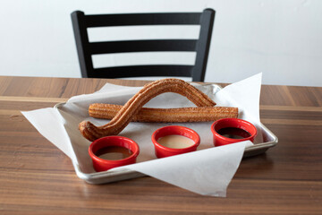Churros on a platter with dipping sauces