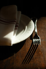 Dramatic light on a fork napkin and plate