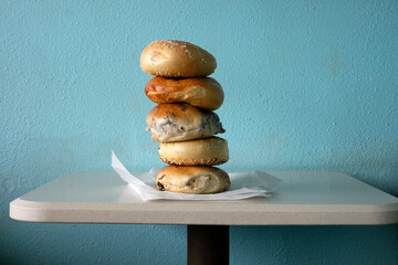 Stack of bagels on a table against a light blue wall horizontal