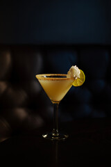 A key lime pie martini cocktail on a table dark background