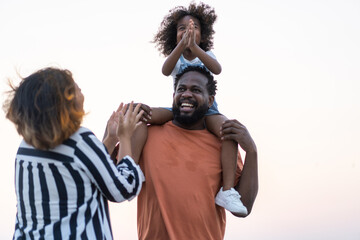 Portrait of enjoy happy love black family.play, having fun, daughter, parenthood, care, superhero.african american father and mother with little african girl child smiling moments good time at home