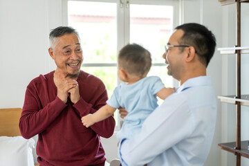 Portrait of enjoy happy love family asian father playing with adorable little asian baby.newborn, infant.dad touching with cute son moments good time in a white bedroom.father day, Love of family