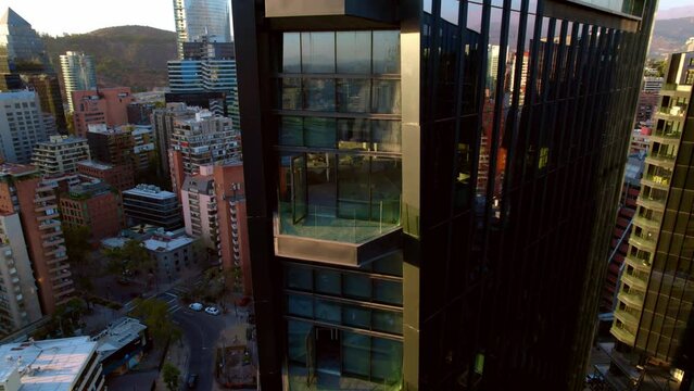 Aerial drone closeup balconies under construction at MUT Santiago de chile urban market with Andean cordillera city background