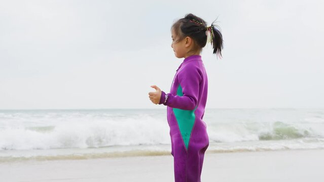 joyful little asian girl playing on the beach at Shimei Bay at Wanning Hainan China in slow motion 