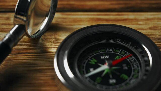 Close-Up of a Classic Compass Beside a Rope on a Wooden Surface During Daylight