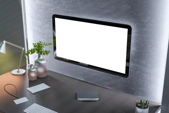 A modern workspace with a blank computer screen, desk lamp, vases, and stationery on a wooden tabletop against a textured wall, concept of a home office. 3D Rendering