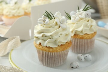 Tasty Easter cupcakes with vanilla cream on table, closeup