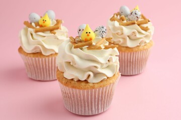 Tasty Easter cupcakes with vanilla cream on pink background, closeup