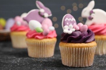 Tasty decorated Easter cupcakes on grey table, closeup