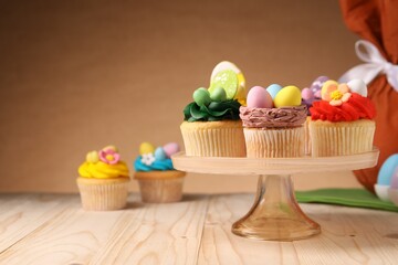 Tasty cupcakes with Easter decor on wooden table, space for text