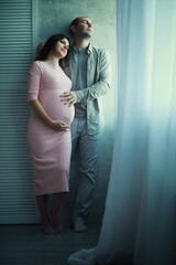 Beautiful pregnant girl with a big belly. Young married pregnant couple. Husband with a pregnant wife. A couple awaiting the birth of a baby.