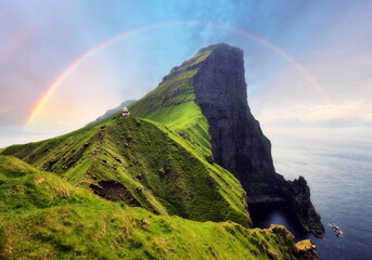 Faroe Island in Denmark with rainbow - Kallur lighthouse on green hills of Kalsoy island on sunset time, Landscape photography