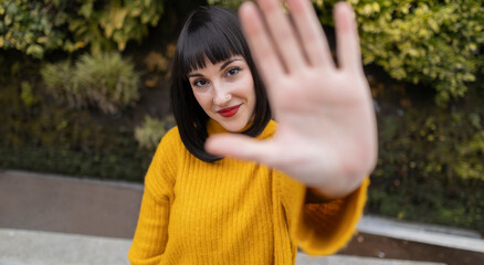 Woman with bangs doing stop gesture