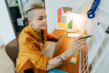 Freelancer checking to do list sitting at desk in home office