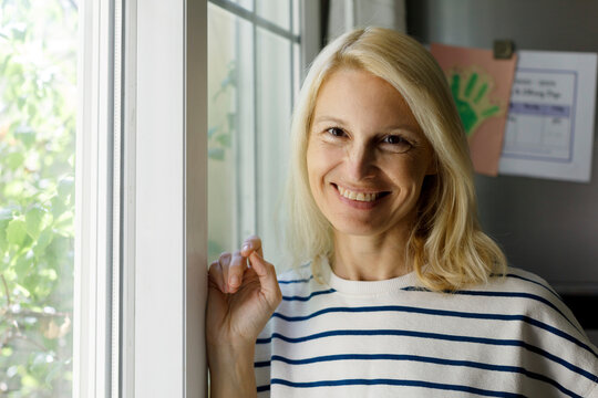 Smiling woman near window at home