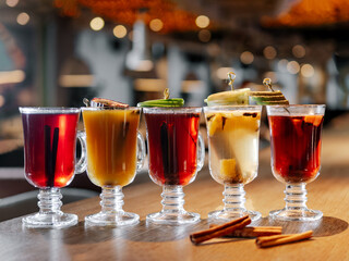 Set of different flavors mulled wine and mulled cider on bar counter in restaurant interior...