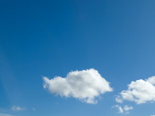 Single white fluffy cumulus cloud in the blue summer sky