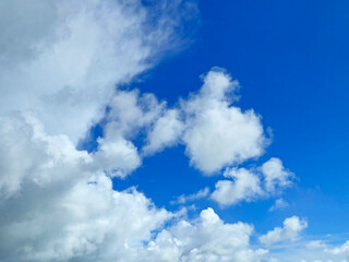 White fluffy cumulus clouds background. Summer clouds in the blue sky