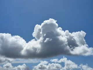 White fluffy cumulus clouds background. Summer clouds in the blue sky